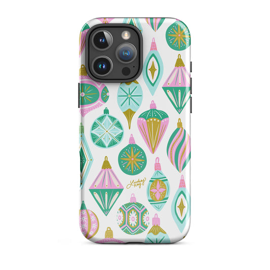 Hand-drawn retro Christmas ornament iPhone case in pastel green, pink, blue, and gold. Festive holiday phone case available in Clear, Tough, MagSafe Clear, and MagSafe Tough for iPhone 11 through iPhone 17. Durable, protective, and illustrated by Lindsey Kay Collective — female-owned small business, no AI used.