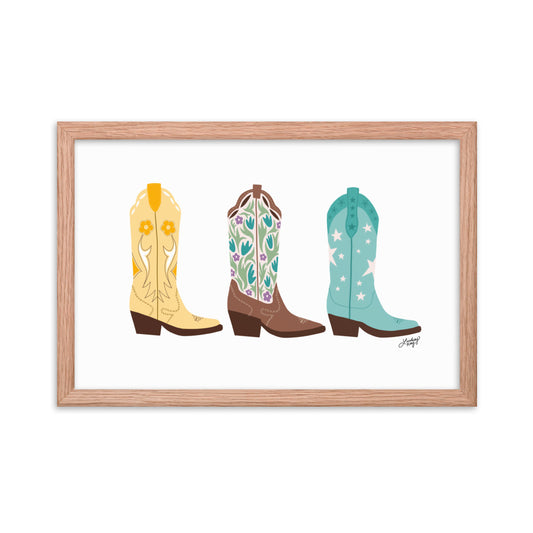 Framed hand-illustrated pastel cowgirl boots art print on matte paper, available in white, black, or brown wood frame, Western wall decor for rustic or boho spaces.